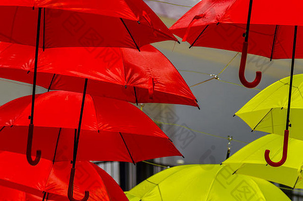 彩色雨伞城市街道装饰。蓝天上挂着五颜六色的雨伞，旅游胜地，阳光明媚的日子