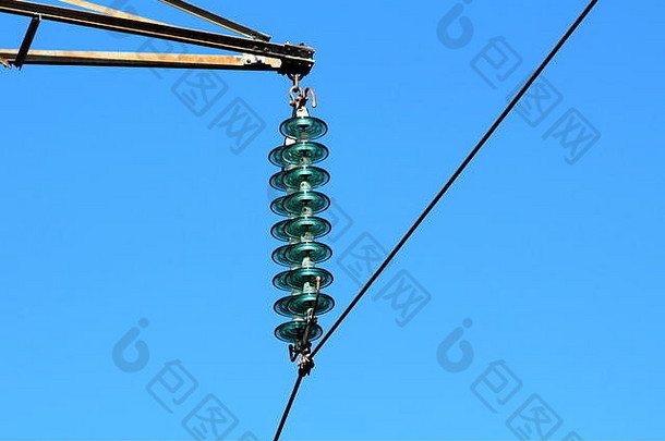 分层高质量高玻璃电力线公用绝缘子，在晴朗蓝天背面的坚固金属公用电线杆上固定单根黑色电线