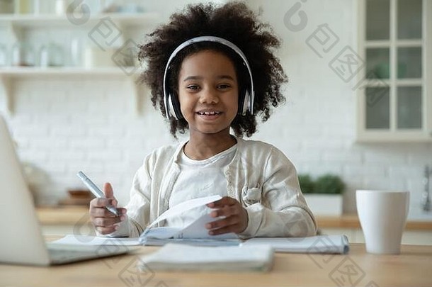笑容可掬的混血女孩在家在线学习的照片
