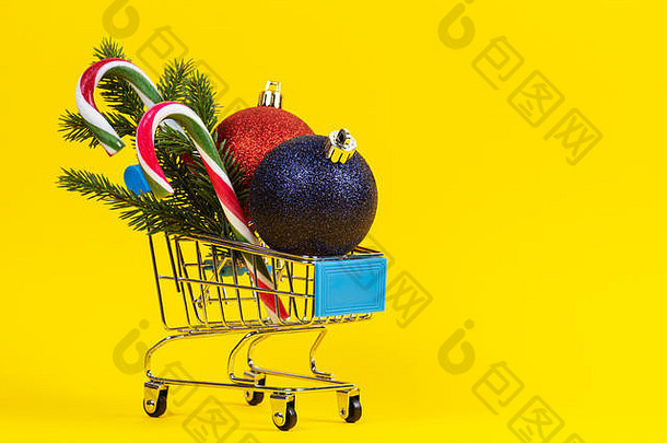 迷你购物车圣诞节装饰装饰物冷杉树分支糖果拐杖黄色的背景