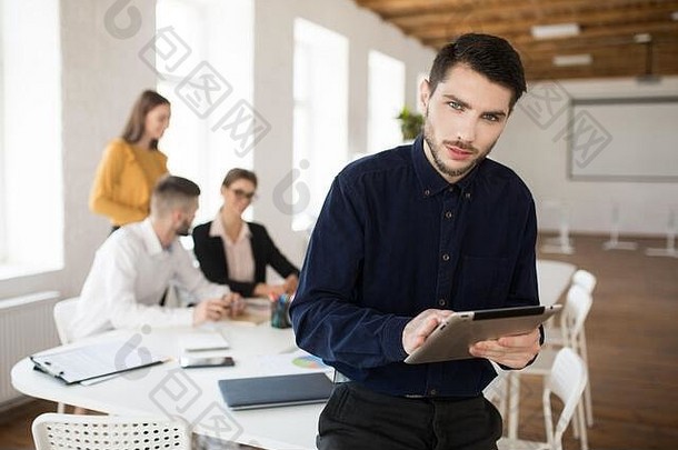 年轻的业务男人。胡子衬衫深思熟虑相机持有平板电脑手办公室的同事们背景