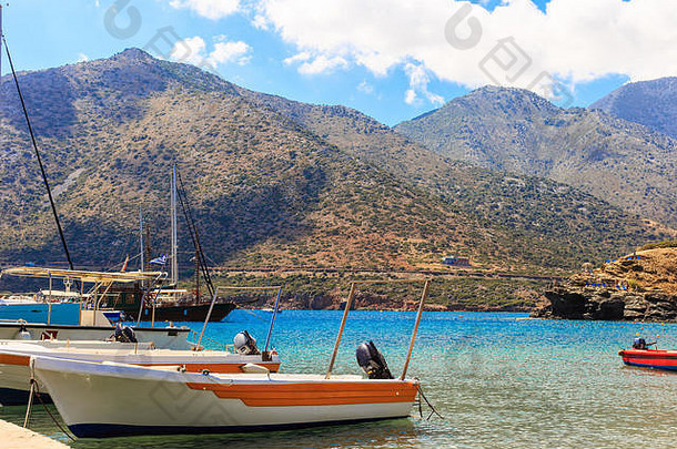 希腊克里特岛渔村巴厘岛码头上的小渔船，背景为群山