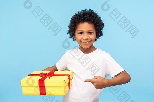 快乐英俊可爱的小男孩指着<strong>礼品</strong>盒，对着镜头微笑，学龄前儿童<strong>展示</strong>礼物，高兴满意的生日惊喜。