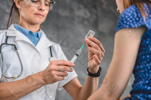 儿科医生准备给病人注射疫苗的女医生