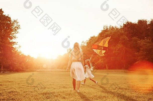 鲜艳的颜色。妈妈和女儿在田野里玩<strong>风筝</strong>。美丽的自然