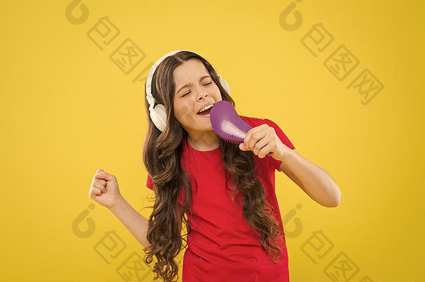 卡拉OK明星。可爱的小女孩在黄色背景下假装唱卡拉OK。表演卡拉OK的可爱的孩子。表演卡拉OK<strong>配乐</strong>的小歌手。