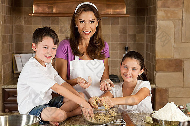 有吸引力的微笑妈妈。儿子女儿家庭烹饪烘焙巧克力芯片饼干厨房首页