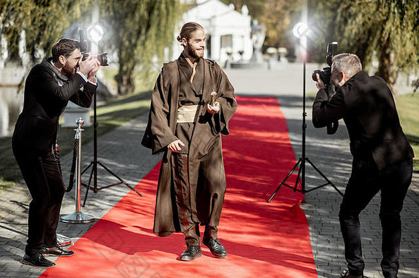 在颁奖典礼的红<strong>地毯</strong>上，一个穿着戏服的男人和一个讨厌的摄影记者走在一起