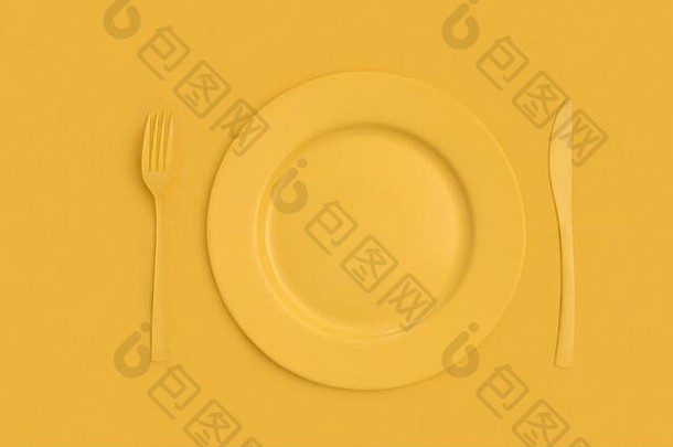 黄色的菜板刀叉黄色的背景前视图单色