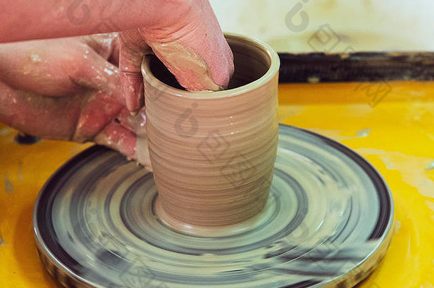 关于用陶工的轮子制作陶瓷壶的硕士班。陶器正在绕轴线旋转。