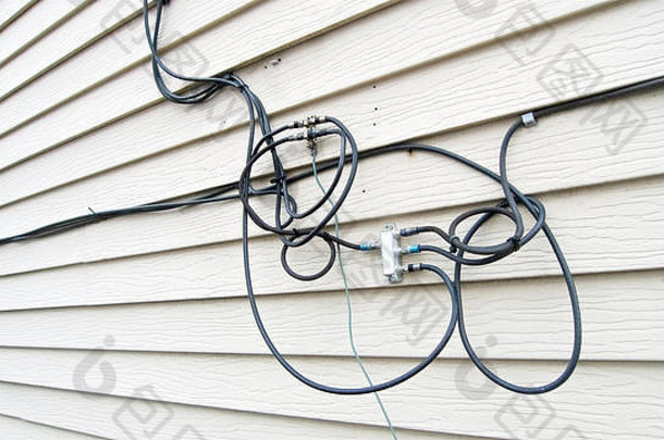 连接在独立房屋的壁板上的用于电视、互联网和电话的通信电缆。