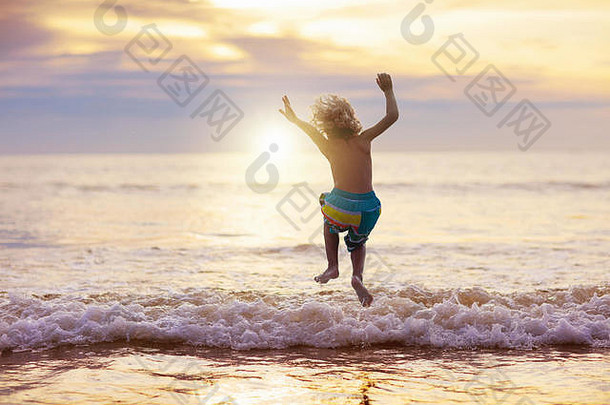 孩子玩海洋海滩孩子跳波日落海假期家庭孩子们男孩运行热带海滩异国情调的