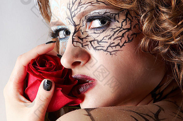 美丽模特的肖像，歪斜的身体艺术和红玫瑰的发型