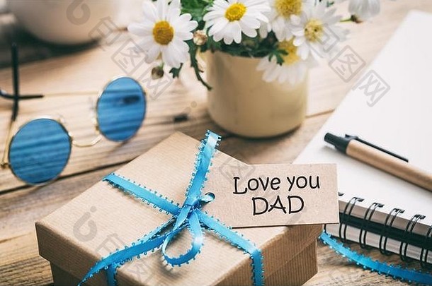 父亲的一天概念礼物盒子蓝色的丝带爱爸爸标签模糊办公室桌子上背景