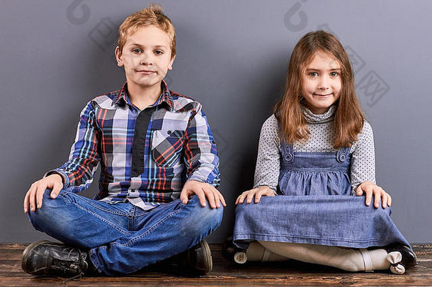 两个孩子交叉着腿坐着。