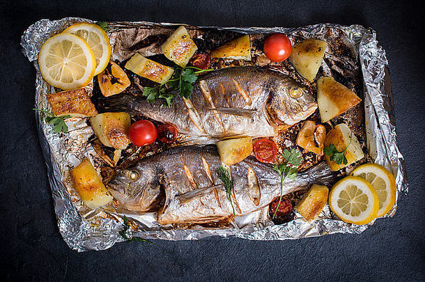 准备好并烤好的吉尔西亚鱼，上面有蔬菜和土豆
