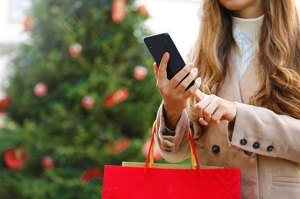 购物妇女在圣诞节期间使用智能<strong>手机</strong>进行网上购物和提包。