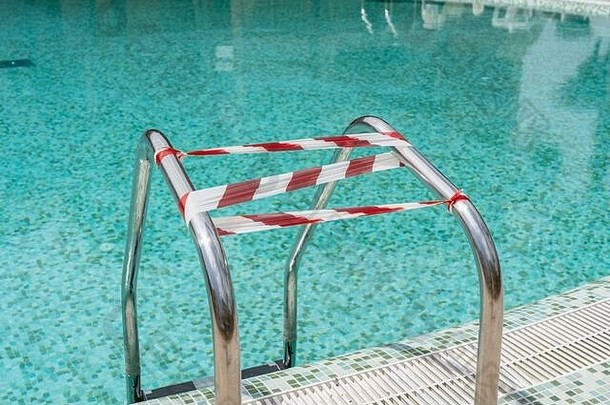在冠状病毒爆发期间，游泳池被包裹在一条禁止进入的胶带中。