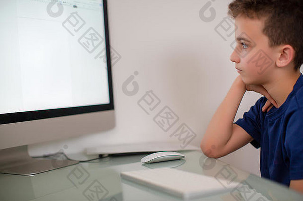 在家里使用电脑的愁眉苦脸的少年