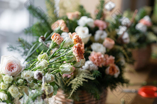 木桌上的柳条篮中有一大束鲜花、桃花康乃馨和白玫瑰，家居装饰，复古风格