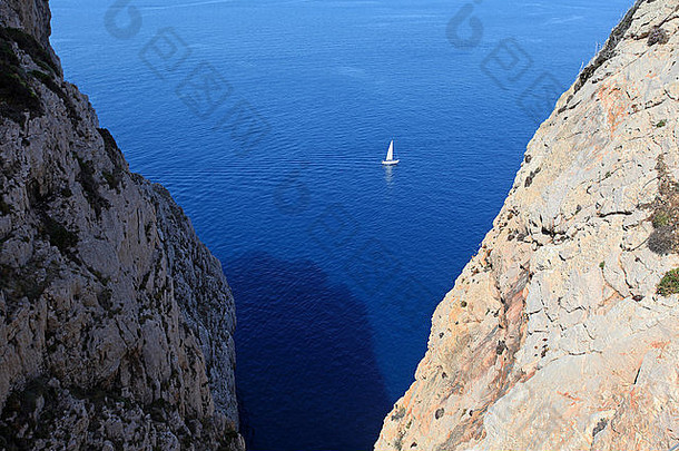 岩石之间的帆船。撒丁岛阿尔盖罗。意大利