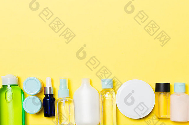 黄色背景上的一套奶油和化妆品瓶和罐。车身护理概念，为您的设计留出空间。