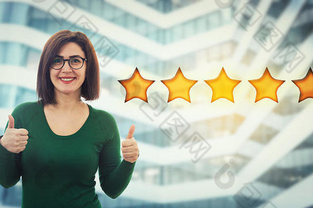 休闲微笑年轻的女人穿眼镜显示拇指手势选择星星评级积极的反馈优秀的客户服务
