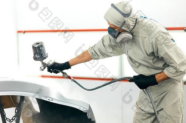 汽车修理工穿着防护服用喷粉碎机粉刷汽车保险杠