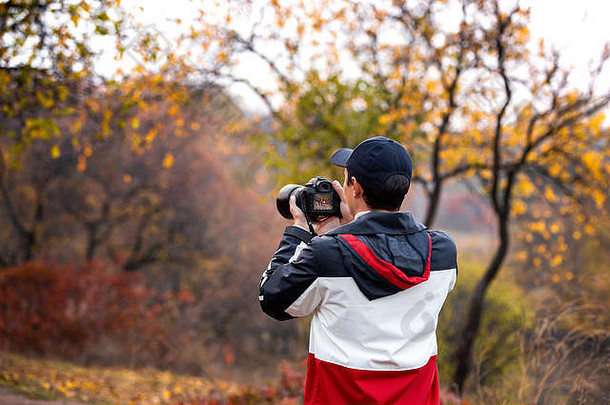 专业摄影师拍摄秋天公园里的一家人