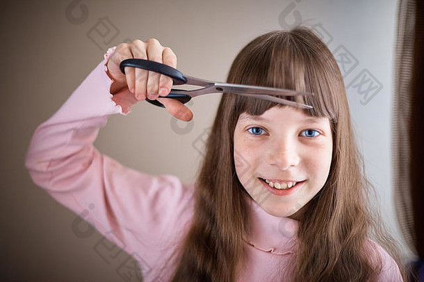女孩雀斑蓝色的眼睛剪刀削减头发