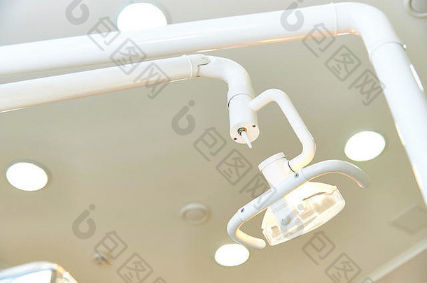 А牙科手术椅上方的发光灯背景上的特写镜头带拱腹的天花板