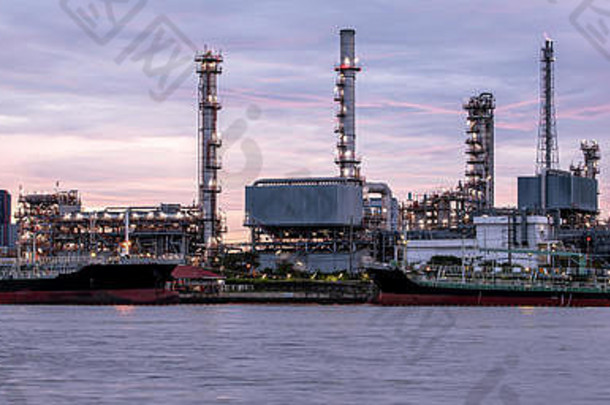 黄昏时分，河边炼油厂的旗帜。原油机械