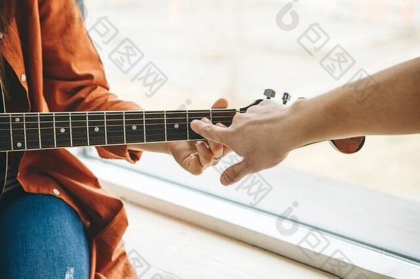 学习弹吉他。老师向学生讲解弹吉他的基本知识。个人家庭教育或课外课程。