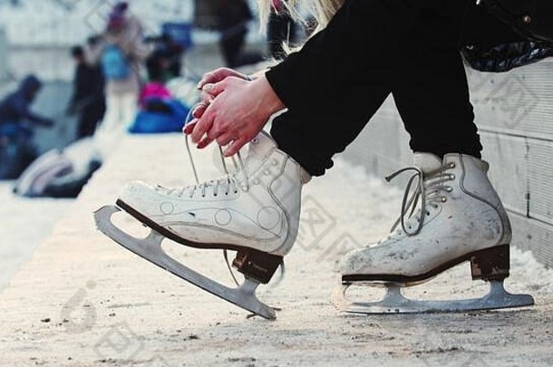 女人手解开数字溜冰鞋