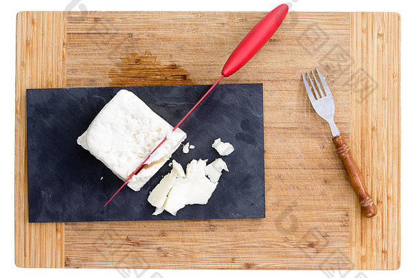 前视图红色的刀切割白色羊奶酪紫色的纸细木切割董事会包括叉
