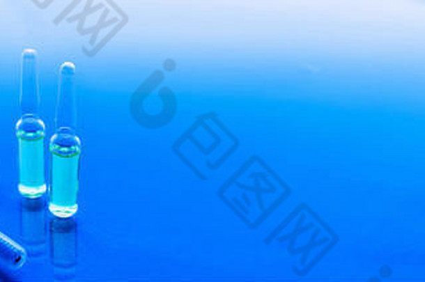 蓝色背景上的注射器、药瓶。疫苗接种概念。横幅
