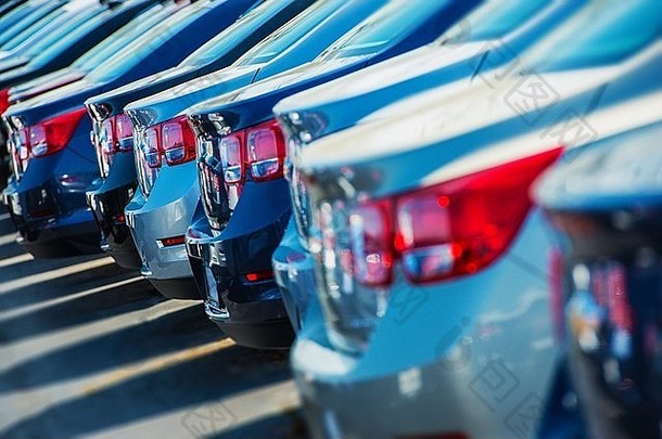 把车停在停车场上。汽车经销商停车场上的一排新车。汽车市场主题。