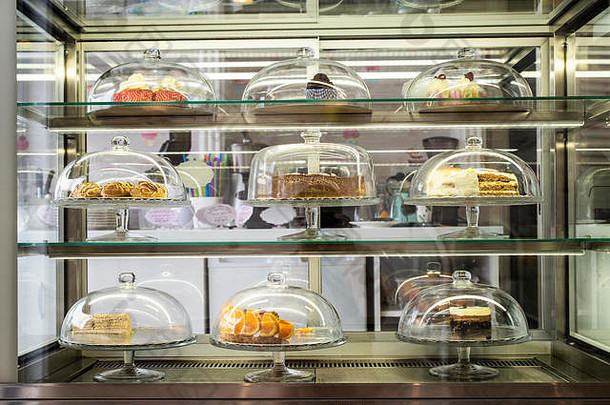 糕点店陈列的糕点和蛋糕。玻璃盖