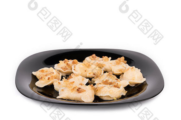 黑盘子上的新鲜饺子，用脆洋葱调味。