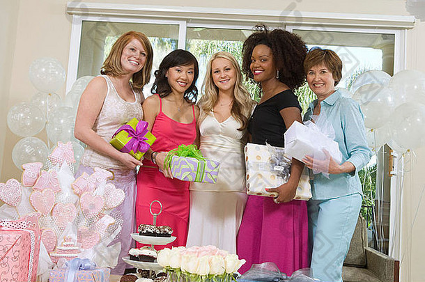 新娘和朋友站在一起，手持礼物参加婚礼