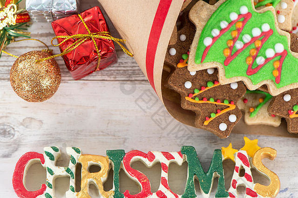 美味可爱的烤<strong>圣诞</strong>饼干（姜饼），带有精美的<strong>圣诞</strong>装饰，装在纸袋中，背景为轻型木制桌子，特写，spac