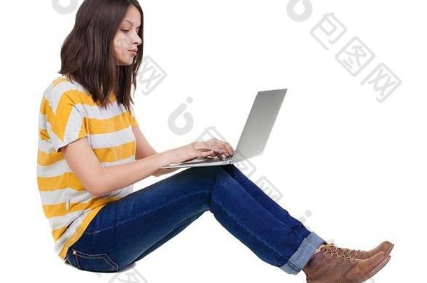 坐在地板上拿着笔记本电脑的女人。
