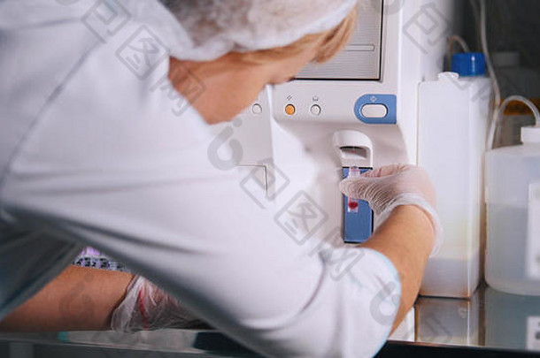 这名妇女在医学实验室使用特殊的血液分析设备