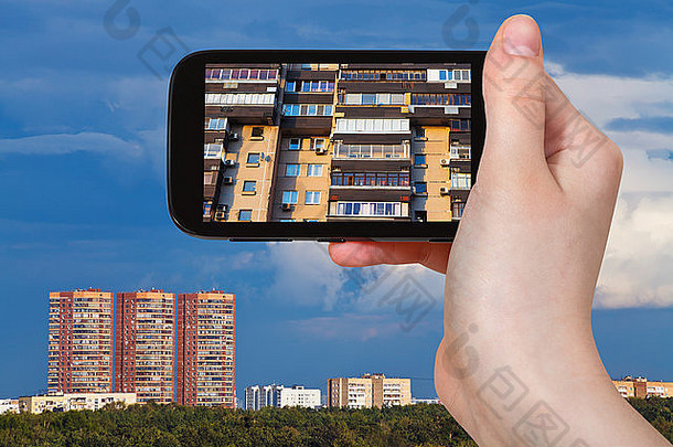 旅游概念-游客在智能手机上拍摄现代住宅正面照片