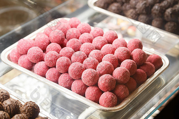 粉色釉面巧克力球。陈列柜上的糖果