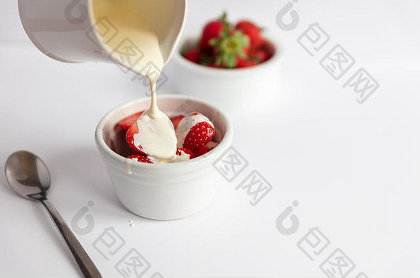 白底白碟中的草莓和奶油