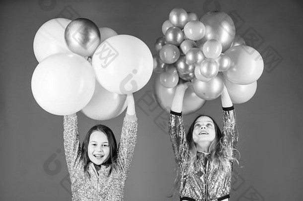 生日聚会。幸福快乐的时刻。无忧无虑的童年。开始这个聚会。姐妹们组织家庭聚会。有趣的概念。气球主题派对。女孩们和小兄弟姐妹们靠近气球。