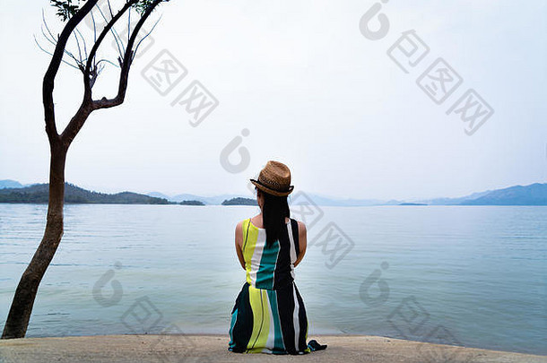 女旅行者喜欢看美丽的湖泊，背景是群山