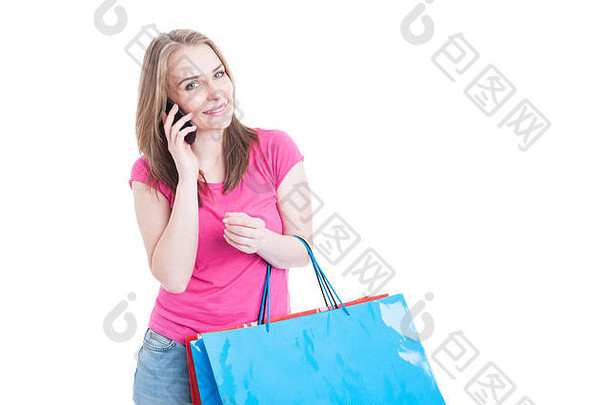 美丽快乐的女人在购物，在<strong>手机</strong>上聊天，手里拿着彩色购物袋，白色的广告空间被隔离