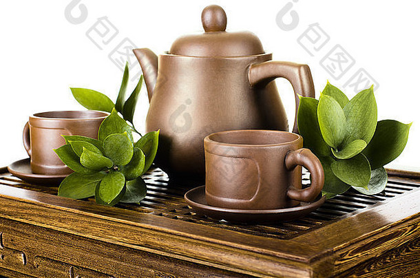 木制三角架上的陶制<strong>茶</strong>壶和<strong>茶</strong>杯的静物画，白色背景，与世隔绝
